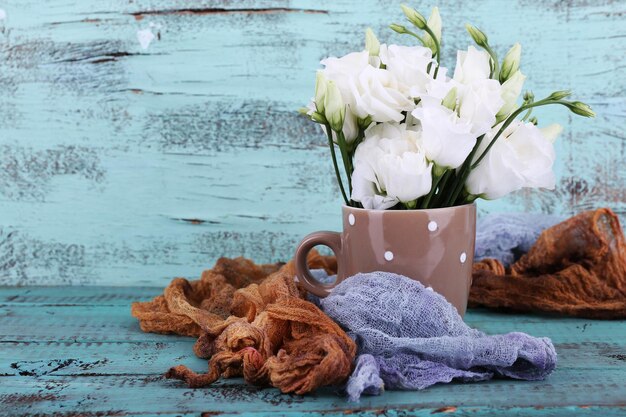 Mooie bloemen in kop op houten achtergrond