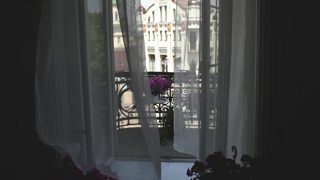 Mooie bloemen op een vintage balkon met tule en uitzicht op de stad