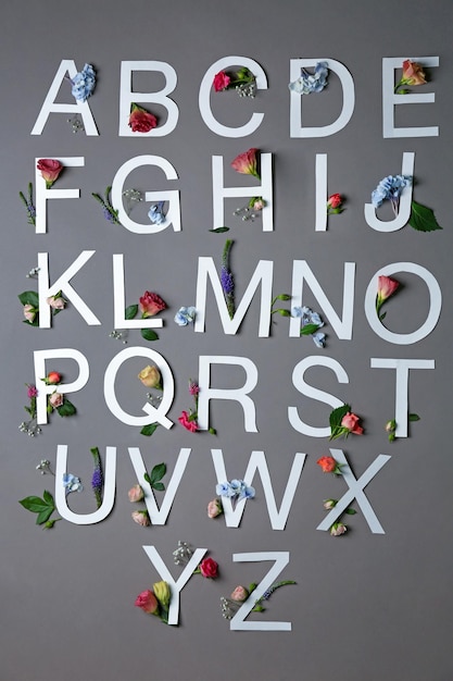 Mooie bloemencompositie met letters gemaakt van papier op grijze achtergrond