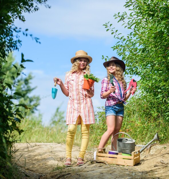 Mooie bloemist op het werk ecologie en milieubescherming aarde dag zomer familie boerderij kinderen houden tuingereedschap landbouw en landbouw lente platteland meisjes boer in dorp