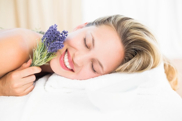 Mooie blonde die op massagelijst ligt met lavanda