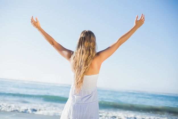 Mooie blonde in witte sundress op het strand