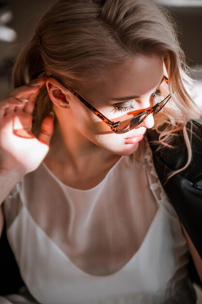 Foto mooie blonde jonge bruid vrouw in witte trouwjurk zwart leren jas en zonnebril rock stijl mode schoonheid foto