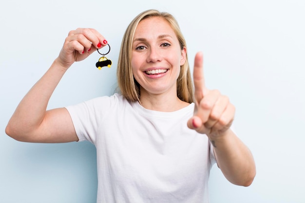 Mooie blonde jonge volwassen vrouw met een autosleutel