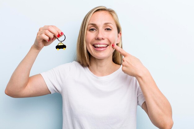 Mooie blonde jonge volwassen vrouw met een autosleutel