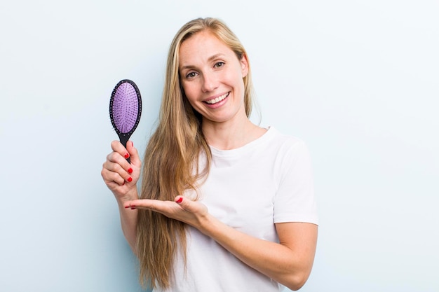 Mooie blonde jonge volwassen vrouw met een haarkam