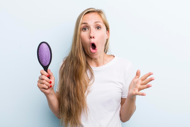 Mooie blonde jonge volwassen vrouw met een haarkam