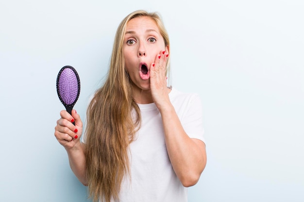 Mooie blonde jonge volwassen vrouw met een haarkam