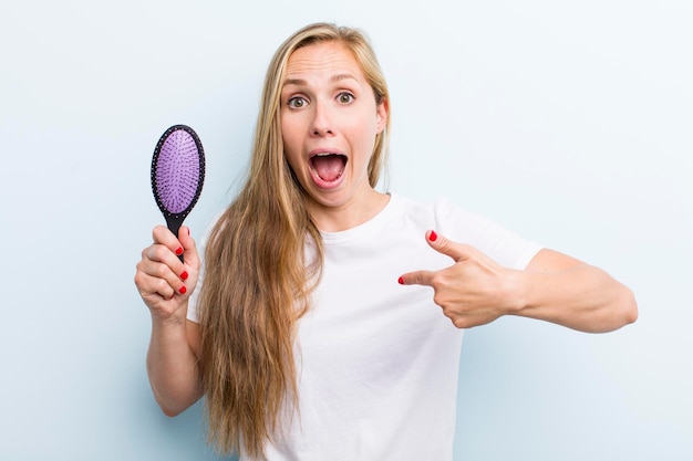 Mooie blonde jonge volwassen vrouw met een haarkam