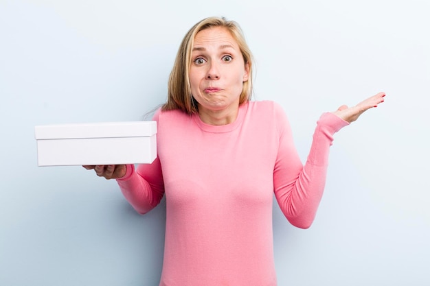 Foto mooie blonde jonge volwassen vrouw met een pizzadoos om mee te nemen