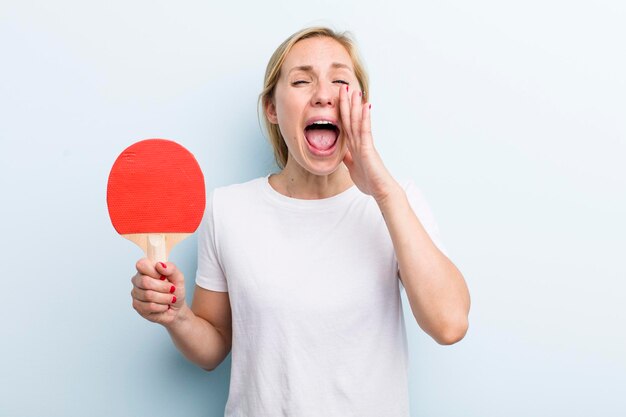 Mooie blonde jonge volwassen vrouw pingpong concept