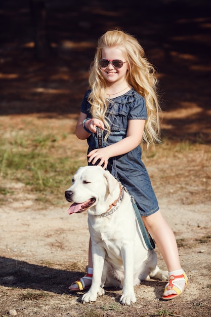 Mooie blonde meisje speelt met haar hond. Outdoor portret. serie