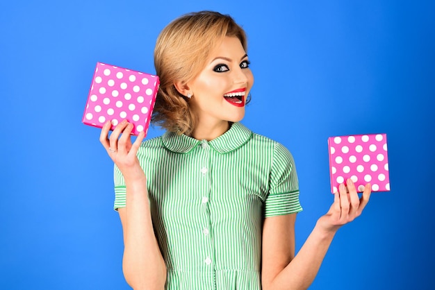 Mooie blonde pinup-stijl meisje houdt cadeaus dozen retro pinup-stijl gelukkige vrouw in retro fashion