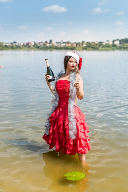 Mooie blonde poseren in water met champagne