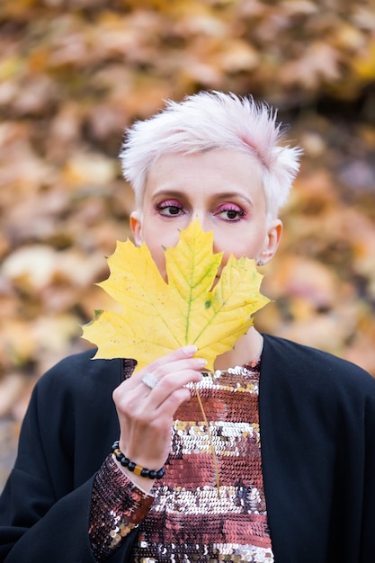 Mooie blonde stijlvolle vrouw in herfst park