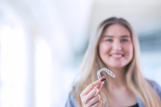 Mooie blonde Turkse vrouw houdt een Invisaligner-kopieerruimte inclusief