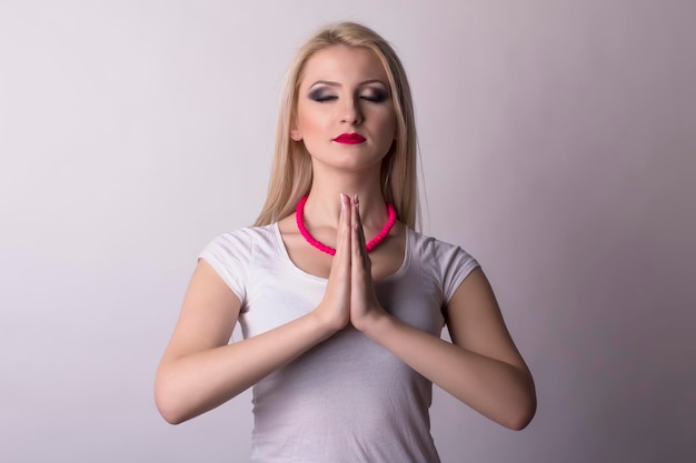 Mooie blonde vrouw bidden. Studio portret