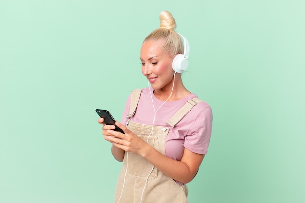 Mooie blonde vrouw die muziek luistert met een koptelefoon