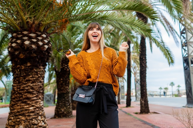 Mooie blonde vrouw die reist en geniet van de herfst in Barcelona,