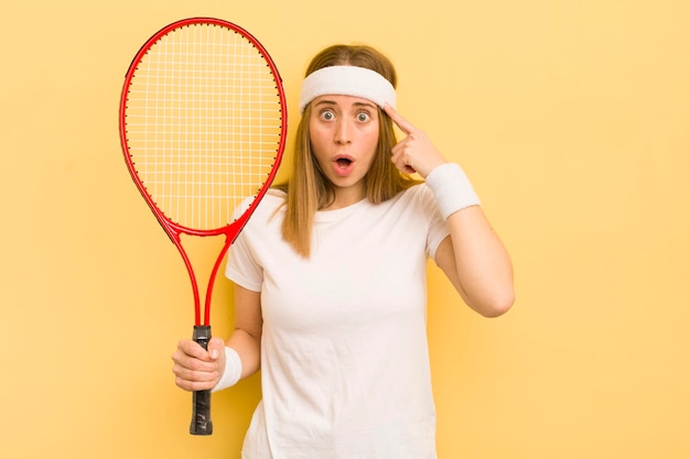 Mooie blonde vrouw die verrast kijkt en een nieuw idee of concept tennisconcept realiseert