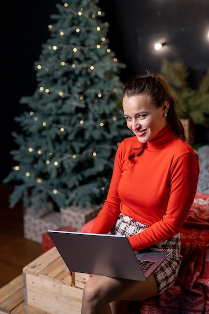 Mooie blonde vrouw die voor Kerstmis voor haar familie winkelt met laptop en creditcard