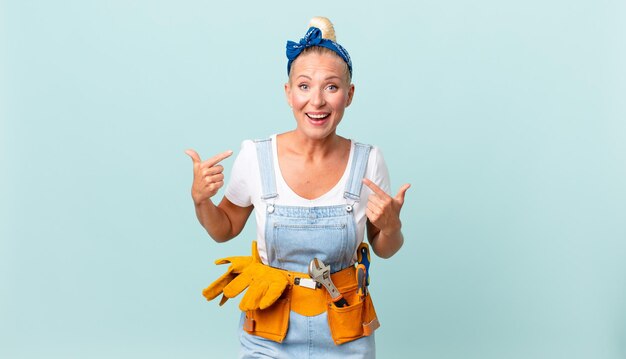 Mooie blonde vrouw die zich gelukkig voelt en naar zichzelf wijst met een opgewonden en reparerend huisconcept