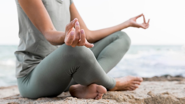 Foto mooie blonde vrouw doet yoga op het strand