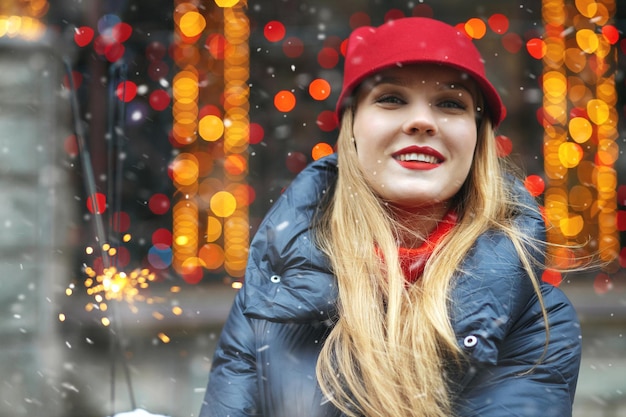 Mooie blonde vrouw draagt rode hoed spelen met Bengaalse lichten op de vakantiebeurs. Ruimte voor tekst