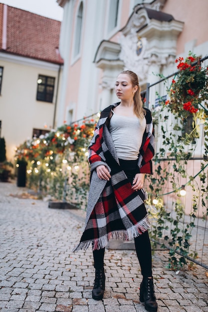 Mooie blonde vrouw in een bloemenbinnenplaats