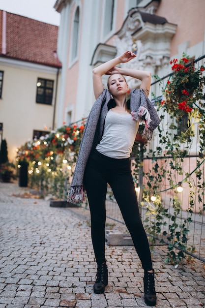 Mooie blonde vrouw in een bloemenbinnenplaats