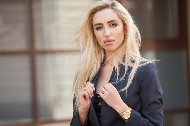 Mooie blonde vrouw in een elegant pak