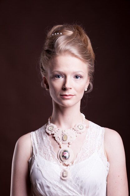 Mooie blonde vrouw in vintage Victoriaanse jurk. Rijk en vintage. Luxe en elegantie. Studiofoto