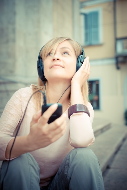 Foto mooie blonde vrouw, luisteren naar muziek