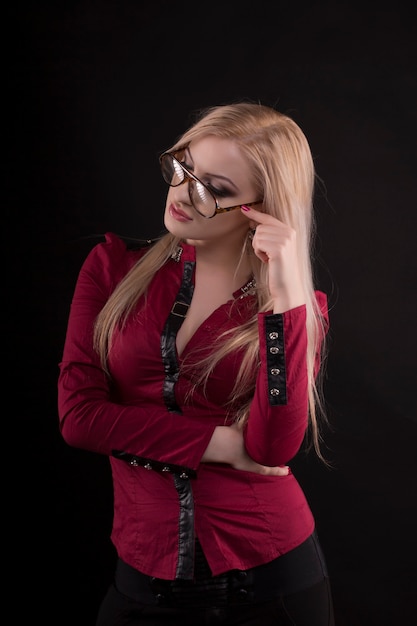 Mooie blonde vrouw met een bril en gekleed in een rode blouse