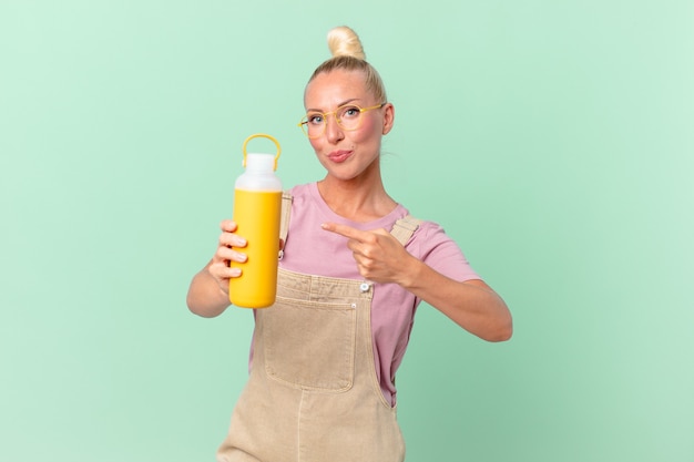 Mooie blonde vrouw met een koffiethermos