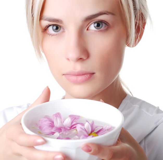 Mooie blonde vrouw met kom bloemen