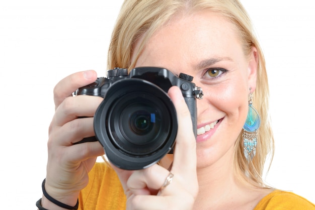 Mooie blonde vrouwenfotograaf met camera, op wit