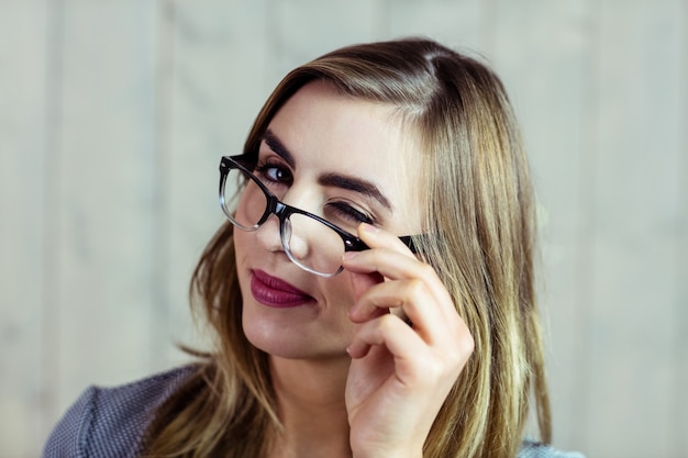 Mooie blondevrouw die naar de camera knipperen