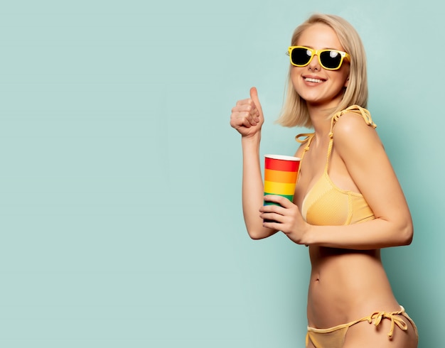 Mooie blondevrouw in bikini met document kop