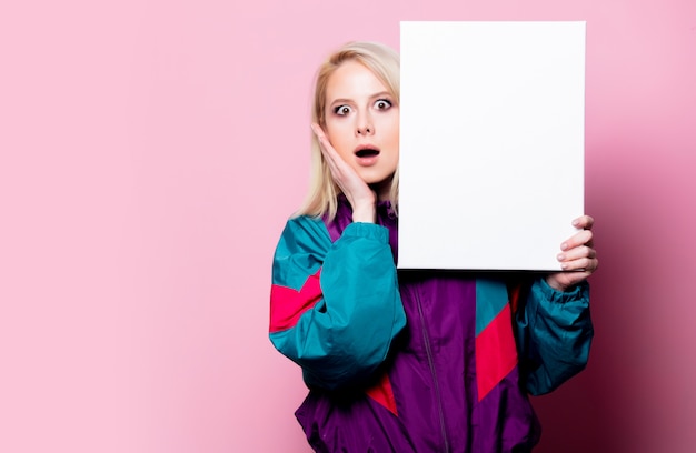 Foto mooie blondevrouw met banner op roze muur