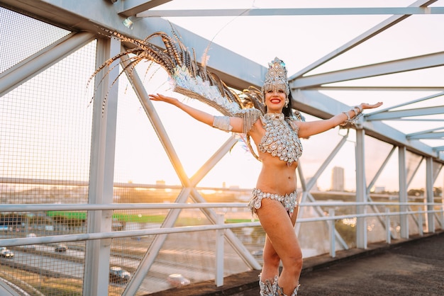 Mooie Braziliaanse vrouw die een kleurrijk carnavalskostuum draagt en glimlacht tijdens de straatparade van Carnaval in de stad.