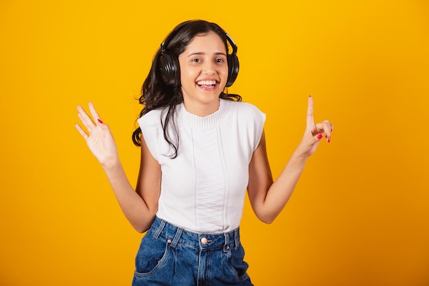 Mooie braziliaanse vrouw die met koptelefoon naar muziek luistert en danst