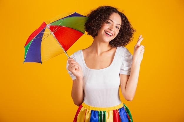 Mooie Braziliaanse vrouw gekleed in carnaval kleding kleurrijke rok en wit overhemd juichend teken van geluk wensen