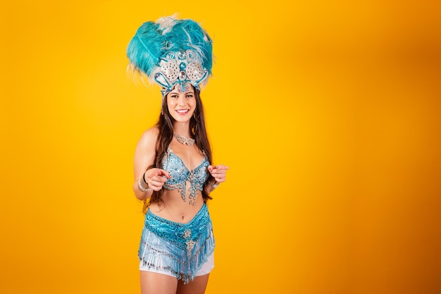 Mooie braziliaanse vrouw met koninginkleren van sambaschool carnaval Verenkroon wijzend op camera