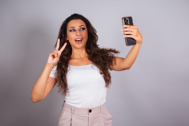 Mooie braziliaanse vrouw met smartphone die zelfportret Selfie doet