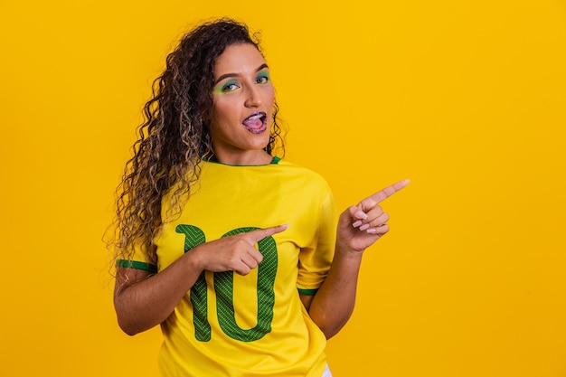 Mooie Braziliaanse vrouwelijke cheerleader die naar de zijkant wijst op vrije ruimte voor tekst