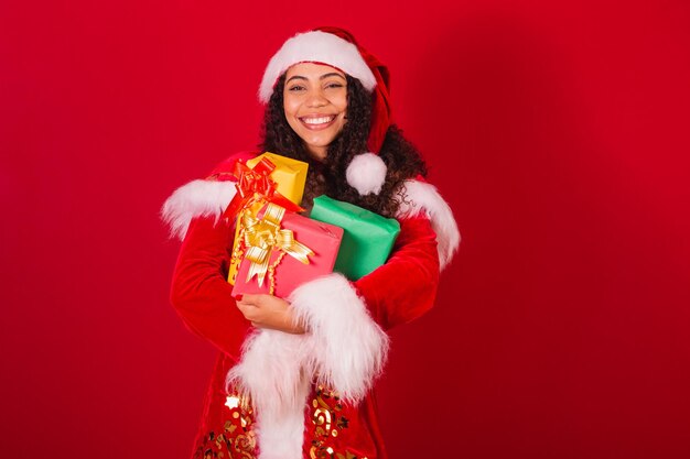 Mooie Braziliaanse zwarte vrouw verkleed als kerstkleren van de kerstman met drie geschenken