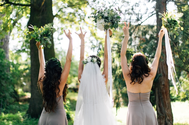 Mooie bruid en bruidsmeisje houden boeketten bloemen in handen