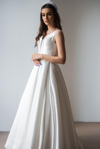 Mooie bruid in een luxe trouwjurk op witte achtergrond