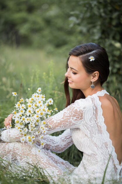 Mooie bruid met bloemen buitenshuis